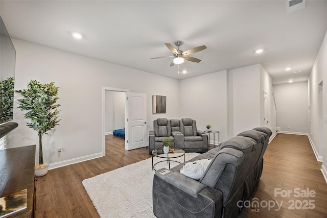 living room featuring dark wood-type flooring and ceiling fan