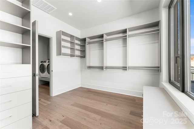 walk in closet featuring light hardwood / wood-style flooring and washer and dryer