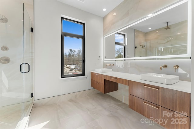 bathroom with a shower with door and vanity