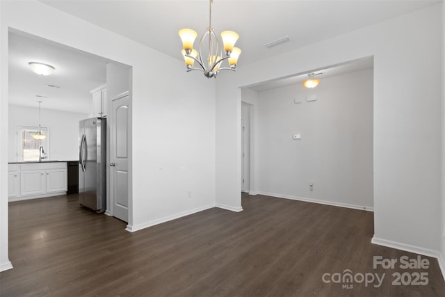 unfurnished dining area with baseboards, visible vents, dark wood finished floors, and a sink