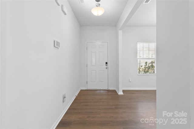 entryway with dark wood finished floors and baseboards