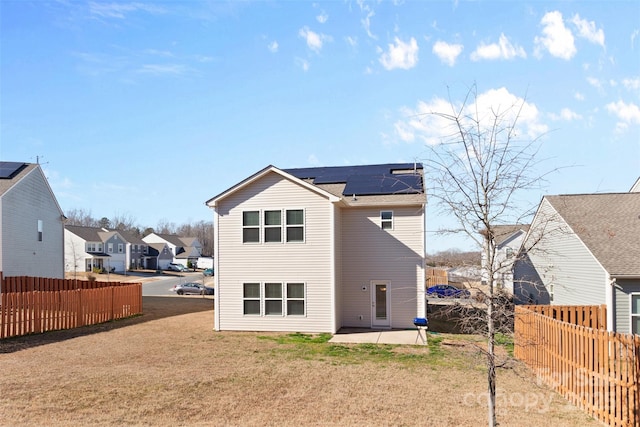 rear view of property featuring a yard, a patio area, a fenced backyard, and a residential view