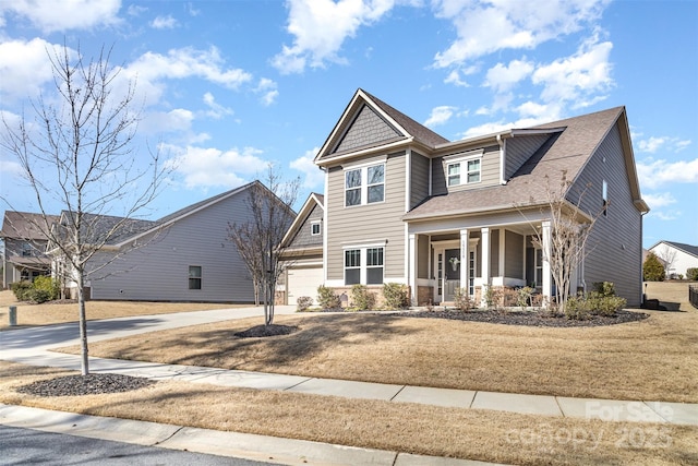 craftsman inspired home with a garage, driveway, a porch, and a shingled roof