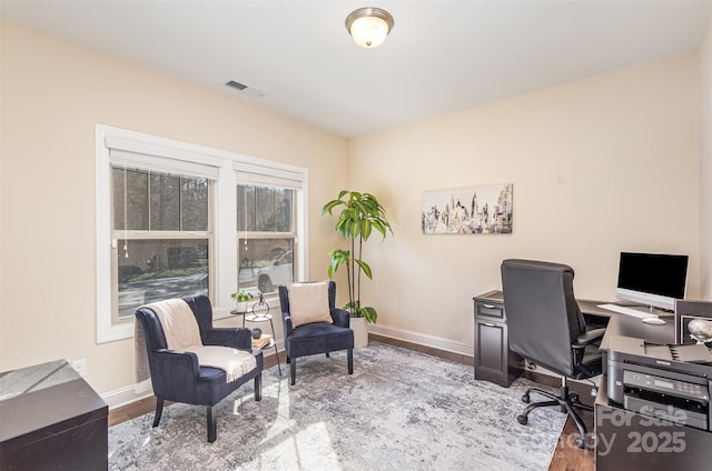 office area featuring light wood finished floors, visible vents, and baseboards