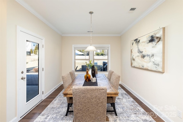 dining room with dark wood-style floors, visible vents, ornamental molding, and baseboards