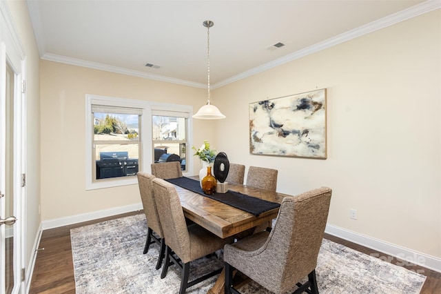 dining space featuring dark wood-style floors, ornamental molding, visible vents, and baseboards