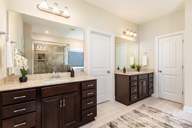 bathroom with a stall shower, visible vents, and vanity