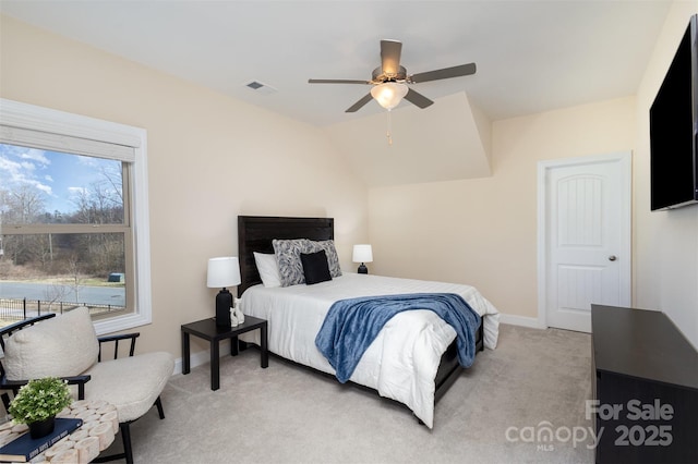 bedroom featuring lofted ceiling, baseboards, visible vents, and light colored carpet