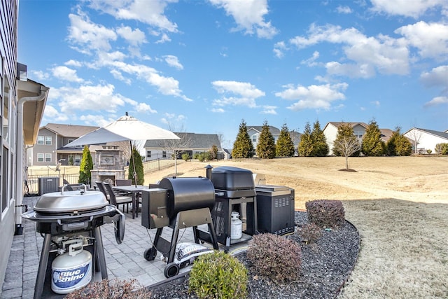 view of patio featuring central AC, outdoor dining space, area for grilling, and fence