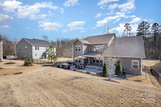 view of front of property with roof with shingles, a patio area, and fence