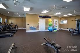 workout area featuring visible vents, baseboards, and a ceiling fan