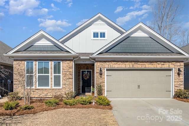 view of front facade featuring a garage, stone siding, board and batten siding, and concrete driveway