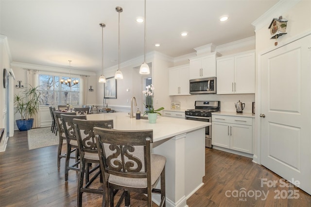 kitchen featuring dark wood-style floors, a breakfast bar, a center island with sink, stainless steel appliances, and light countertops