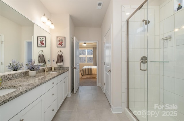 ensuite bathroom with tile patterned flooring, visible vents, a sink, and a shower stall