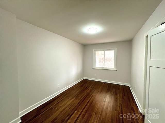 empty room with dark hardwood / wood-style flooring