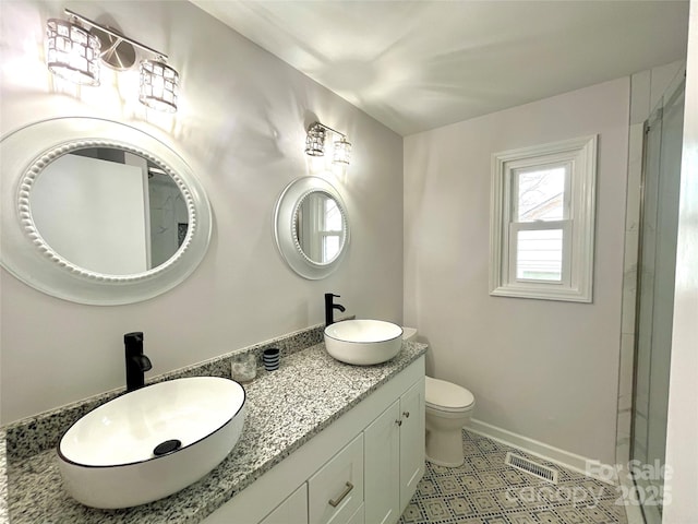 bathroom with a shower with door, vanity, and toilet