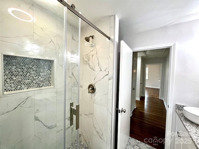 bathroom with vanity, hardwood / wood-style flooring, and a shower with shower door