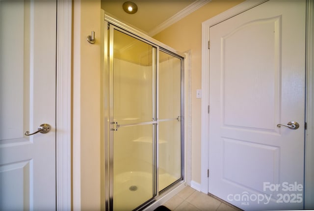 bathroom with walk in shower, ornamental molding, and tile patterned flooring