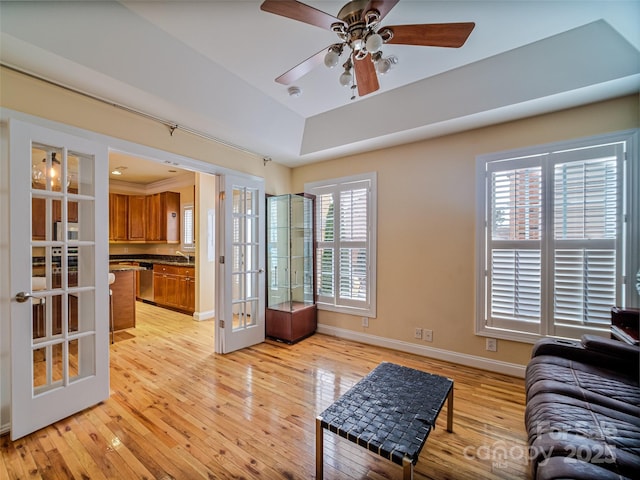 living room with ceiling fan, sink, light hardwood / wood-style floors, and french doors