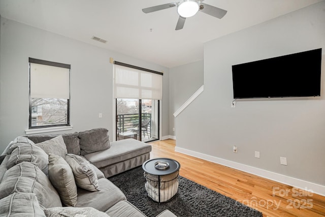 living room featuring ceiling fan and light hardwood / wood-style flooring