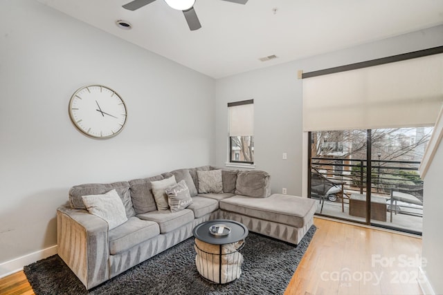 living room with hardwood / wood-style flooring, ceiling fan, and plenty of natural light