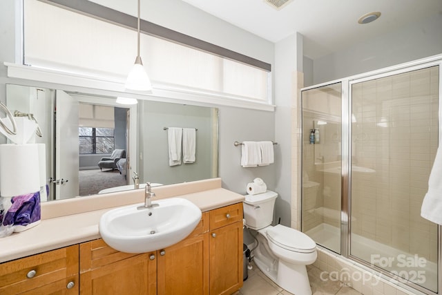 bathroom featuring toilet, tile patterned flooring, an enclosed shower, and vanity