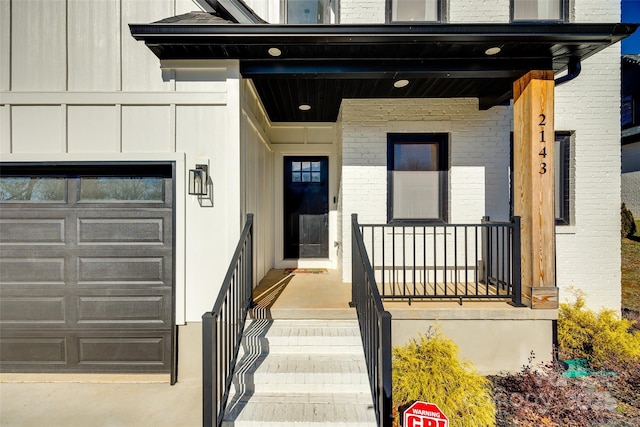 doorway to property with a porch and a garage