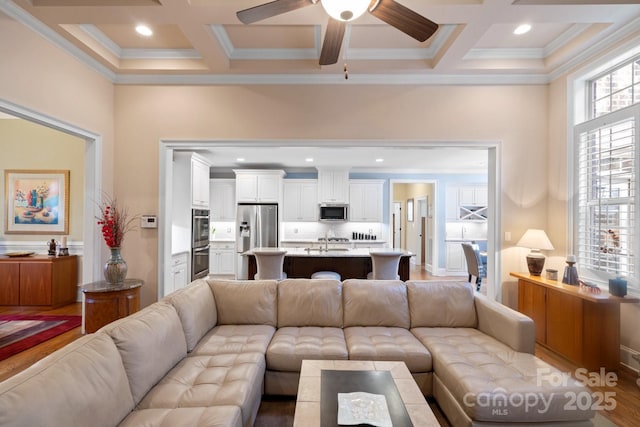 living room featuring beam ceiling, sink, and coffered ceiling