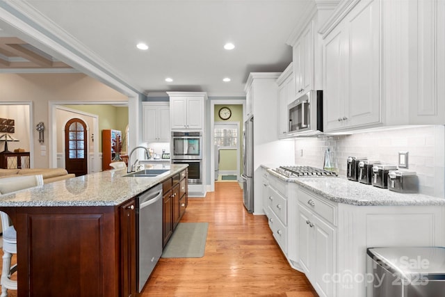 kitchen with white cabinetry, sink, a kitchen bar, and stainless steel appliances