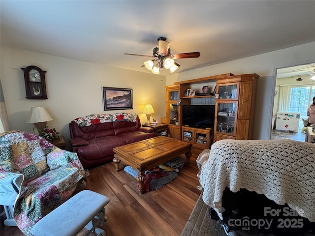 living room with dark wood-type flooring and ceiling fan