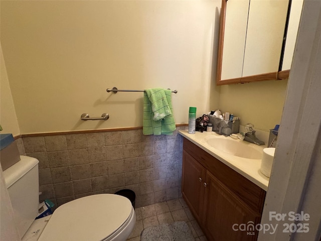 bathroom with vanity, tile walls, tile patterned floors, and toilet