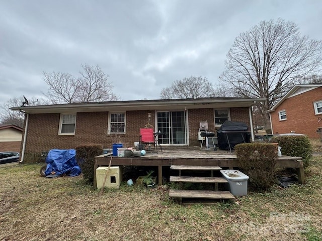 back of property featuring a wooden deck and a lawn