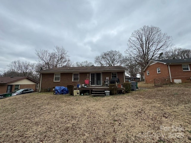 rear view of property with a yard and a deck