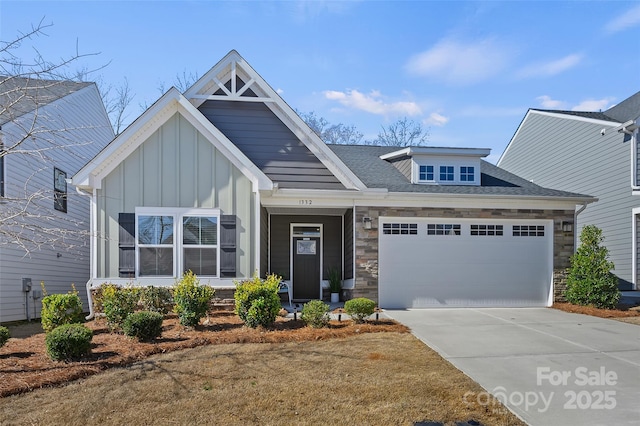 craftsman-style house featuring a shingled roof, board and batten siding, a garage, stone siding, and driveway