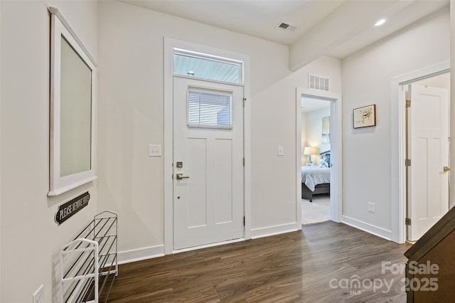 entrance foyer with dark wood-style flooring, visible vents, and baseboards