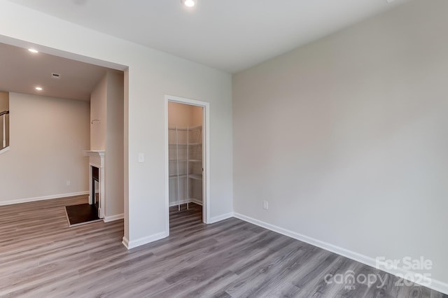 unfurnished bedroom with a closet, a walk in closet, and light hardwood / wood-style flooring