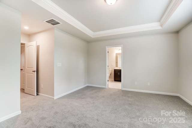 carpeted spare room with ornamental molding and a tray ceiling