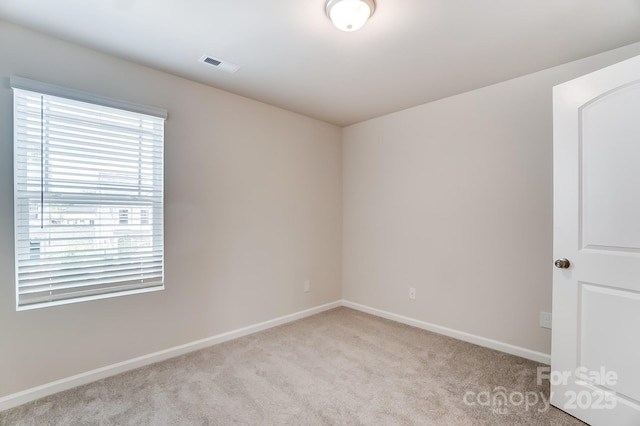 unfurnished room featuring light carpet