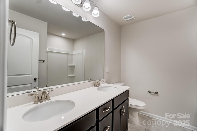 bathroom featuring vanity, tile patterned floors, and toilet