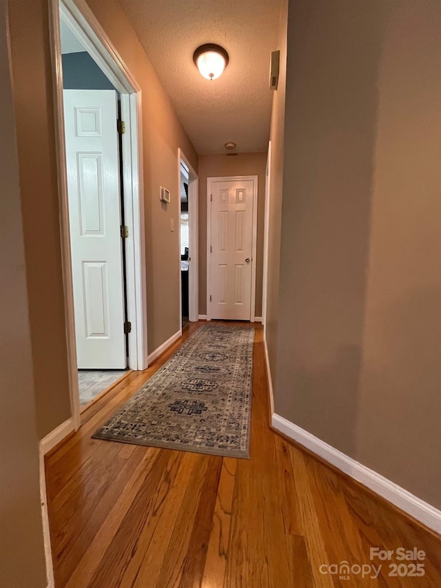 hallway featuring a textured ceiling and light wood-type flooring