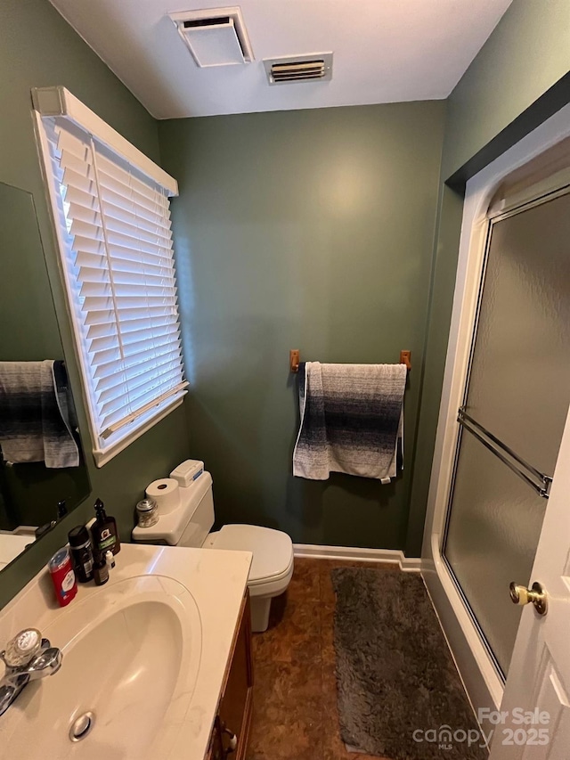 bathroom with vanity, an enclosed shower, and toilet