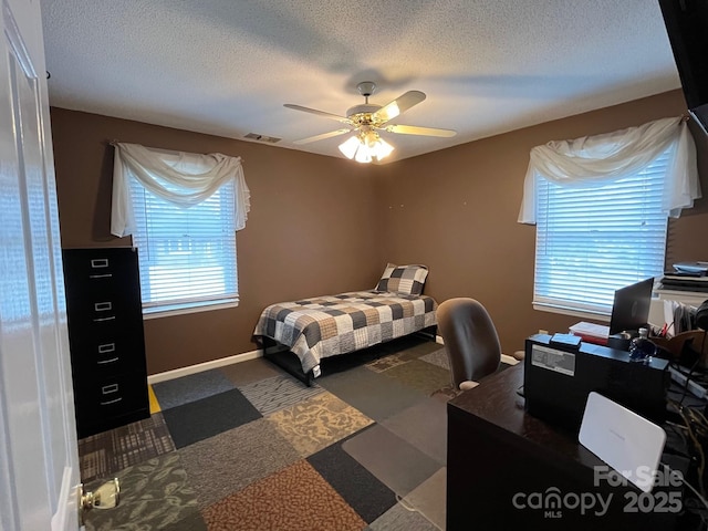 bedroom featuring ceiling fan and a textured ceiling