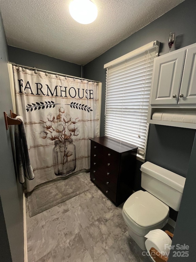 bathroom with a textured ceiling and toilet