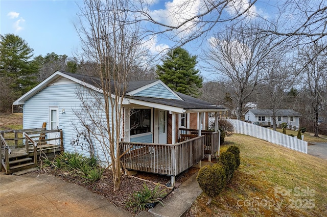 back of house featuring covered porch and a yard