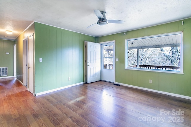 empty room featuring a textured ceiling, ceiling fan, and wood-type flooring