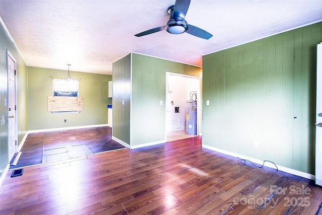 spare room featuring dark wood-type flooring, electric water heater, and ceiling fan