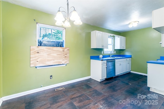 kitchen featuring hanging light fixtures, white cabinets, stainless steel dishwasher, sink, and an inviting chandelier