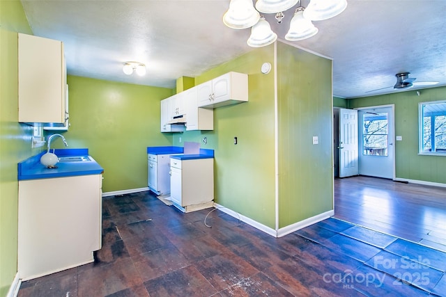 kitchen featuring sink, white cabinetry, ceiling fan, dark hardwood / wood-style flooring, and hanging light fixtures