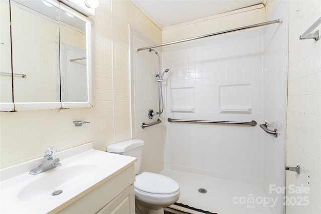 bathroom featuring a tile shower, vanity, tile walls, and toilet