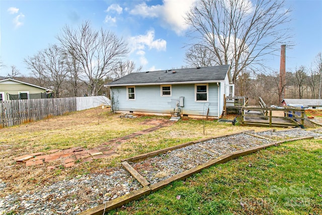 back of house featuring a lawn and a deck